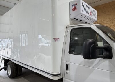 White refrigerated box truck inside a warehouse, with a refrigeration unit on the cab roof and an 11'0" height label visible next to it.